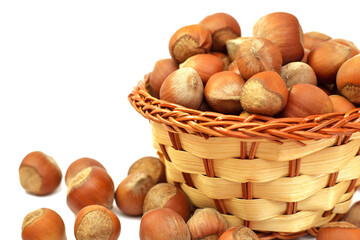 hazelnut in wicker basket isolated on white background.