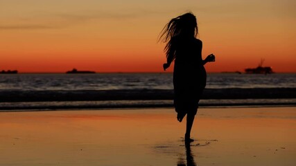 Pretty Asian woman enjoys a walk on the beach at sunset. Slow Motion.