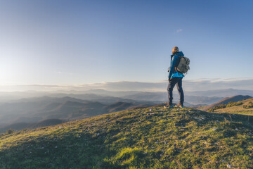 Obraz premium Top of the mount at sunset light.Concetto di successo. Donna in piedi in cime ad una montagna.