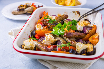 Roasted sausages with vegetables and feta cheese