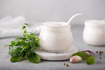 Obraz na płótnie Canvas fresh greek yogurt with herbs and spices in glass jars