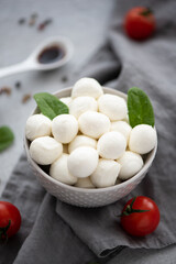 small balls of mozzarella in a gray bowl