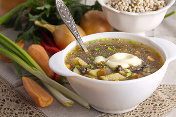 Mushroom broth with vegetables and pearl barley in a white plate