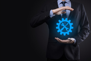 Businessman holding gear icon with tools.Gearing.Concept of target focus digital diagram,graph interfaces,virtual UI screen,connections netwoork.