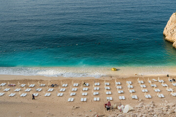 View of the turquoise beach. Beautiful Kaputas Beach in Turkey with people resting under the sun and in the sea