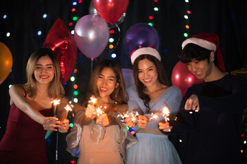 Happy friends celebrating with sparkler fireworks on new year's eve 2021- Different age of people having fun together in patio home party doing selfie - Winter and holidays concept