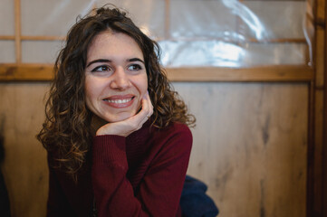 Fototapeta premium Close-up caucasian young woman portrait smiling looking at her side with chin on hand.