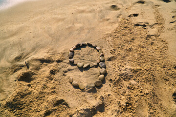 The number nine is laid out in the sand with stones. The number on the shore. Campi and the coast....