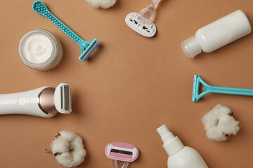 Different shaving accessories on brown background, space for text