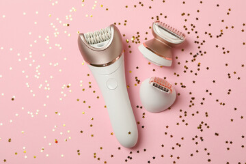 Fototapeta premium Epilator and glitter on pink background, top view
