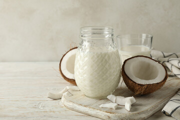 Board with fresh coconut and coconut milk on wooden background