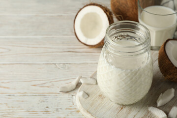 Board with fresh coconut and coconut milk on wooden background