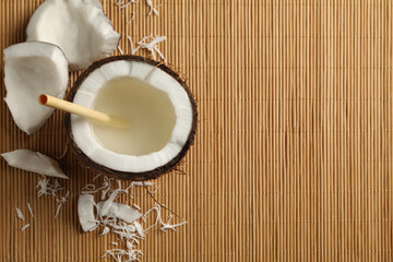 Tasty coconut with straw on bamboo background