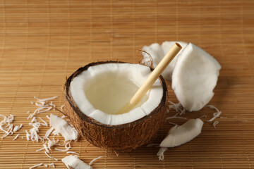 Tasty coconut with straw on bamboo background