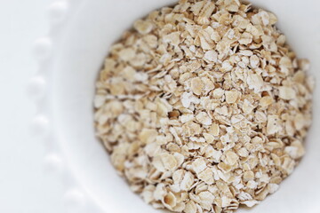 Healthy food ingredient, oatmeal in white bowl with copy space