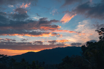 Naklejka premium Panorama of a forest valley with mountains at colorful sunset. View from the balcony.