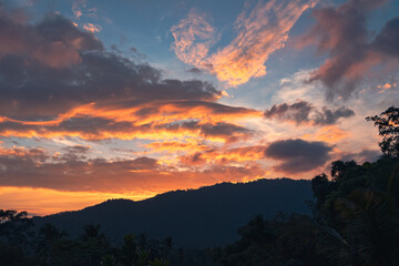 Panorama of a forest valley with mountains at colorful sunset. View from the balcony.