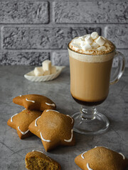 Coffee in a cup, gingerbread, marshmallows on the table. Tasty food.