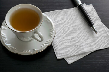 cup of tea, pen and napkin with space for text