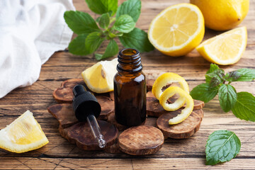 Lemon citrus fruit essential oil and mint, aromatherapy oil natural organic cosmetic on rustic wood background.