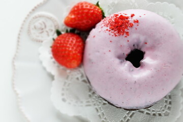 Pink strawberry chocolate coating donut served with strawberry