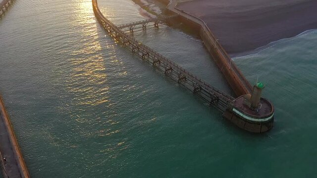 Vue a&eacute;rienne du port de F&eacute;camp et de ses phares au lever du soleil, en Normandie - Mouvement arri&egrave;re avec un drone
