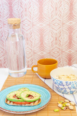 Vertical shot of healthy and vegan breakfast. Avocado toast and yogurt with fruit and seeds