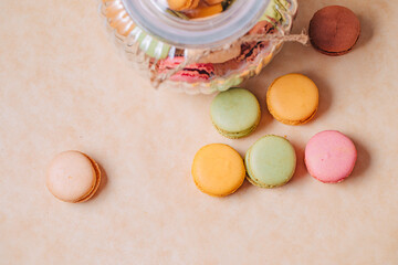 Macaroons of different colors in a glass container. Macarons of different colors