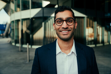 Mixed race businessman smiling walking standing outside office building 