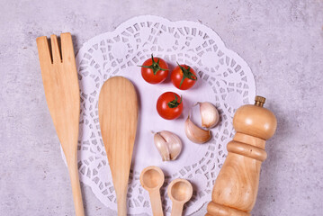 Wooden kitchen tools with red cherry tomato and garlic with peper mill and spices