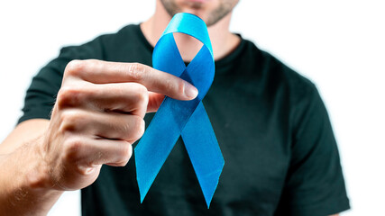 Blue prostate ribbon. Awareness cancer of men health. Hipster men in black shirt with blue ribbon in hands isolated on white background. November and International Mens Day.