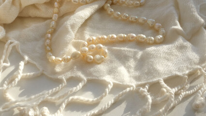 strands freshwater pearls and light beige scarf light and shadow sun rays , copy space.  Bridal...