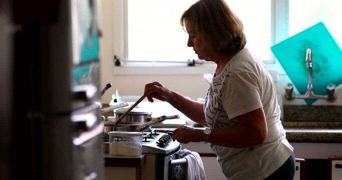 Senior Woman Cooking At Home, Casual Candid Older Person Stirring Pot