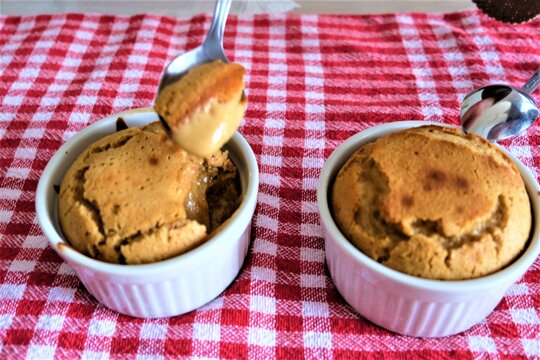 Tahini souffle in classic souffle ramekin. Selective focus. Two souffles in a white ceramic bowl. Classic French meal. Homemade dessert. It is called "Tahinli Sufle" in Turkish. Some areas are blurred