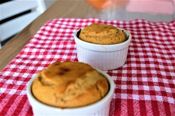 Tahini souffle in classic souffle ramekin. Selective focus. Two souffles in a white ceramic bowl. Classic French meal. Homemade dessert. It is called 
