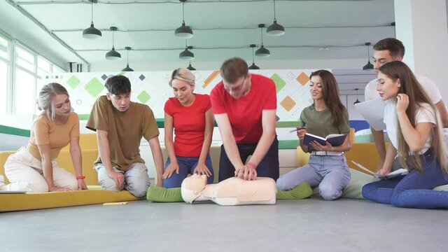 Young woman ask question how to save life by instructor, practice on dummy.