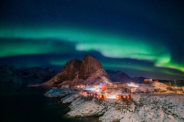 Obraz na płótnie Canvas Aurora borealis on the Hamnoy village in Lofoten islands, Norway. Green northern lights above mountains. Night sky with polar lights. Night winter landscape.