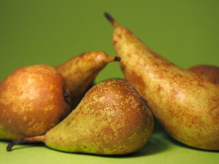 Pile of pears on a green background. Fresh fruit every day.