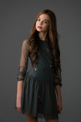 beautiful girl in a stylish dress posing in the studio