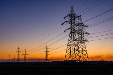 High voltage power line in a field at sunset