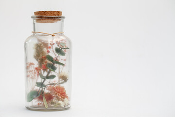 bouquet of dry flowers and potpourri in a glass jar on a white table. High quality photo
