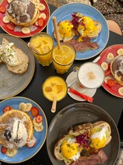 Breakfast brunch with pancakes, orange juice, coffee, eggs on toast, fruits