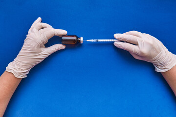 Image of a nurse preparing the vaccine dose on blue background with copy space