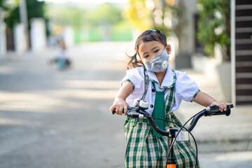 Girl riding bicycle  wearing healthy face mask to prevent virus and PM2.5 pollutions 