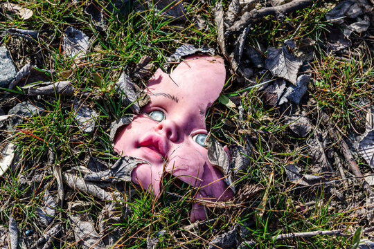 Scary broken doll face on a ground