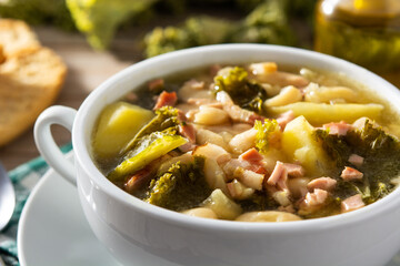 Creamy Tuscan soup in bowl on wooden table	