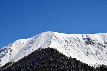 Mountain landscape, winter in the mountains, peaks and snowy peaks, ski slopes.
