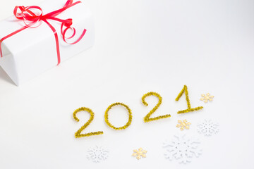 2021 number for New year greeting card. Christmas gift decoration on white background. Golden tinsel and snowflakes.