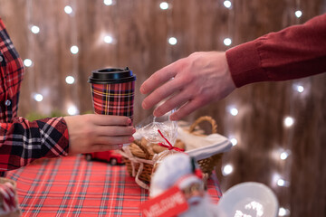 Man  customer buying hot chocolate, coffee in a paper cup, sweets at the christmas bakery. Take away.