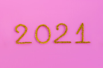 2021 number for New year greeting card. Christmas Party decoration on pink background. Golden tinsel